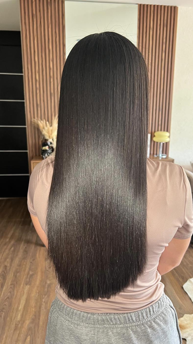 Cabello largo, oscuro y liso con mucho brillo, visto de espaldas