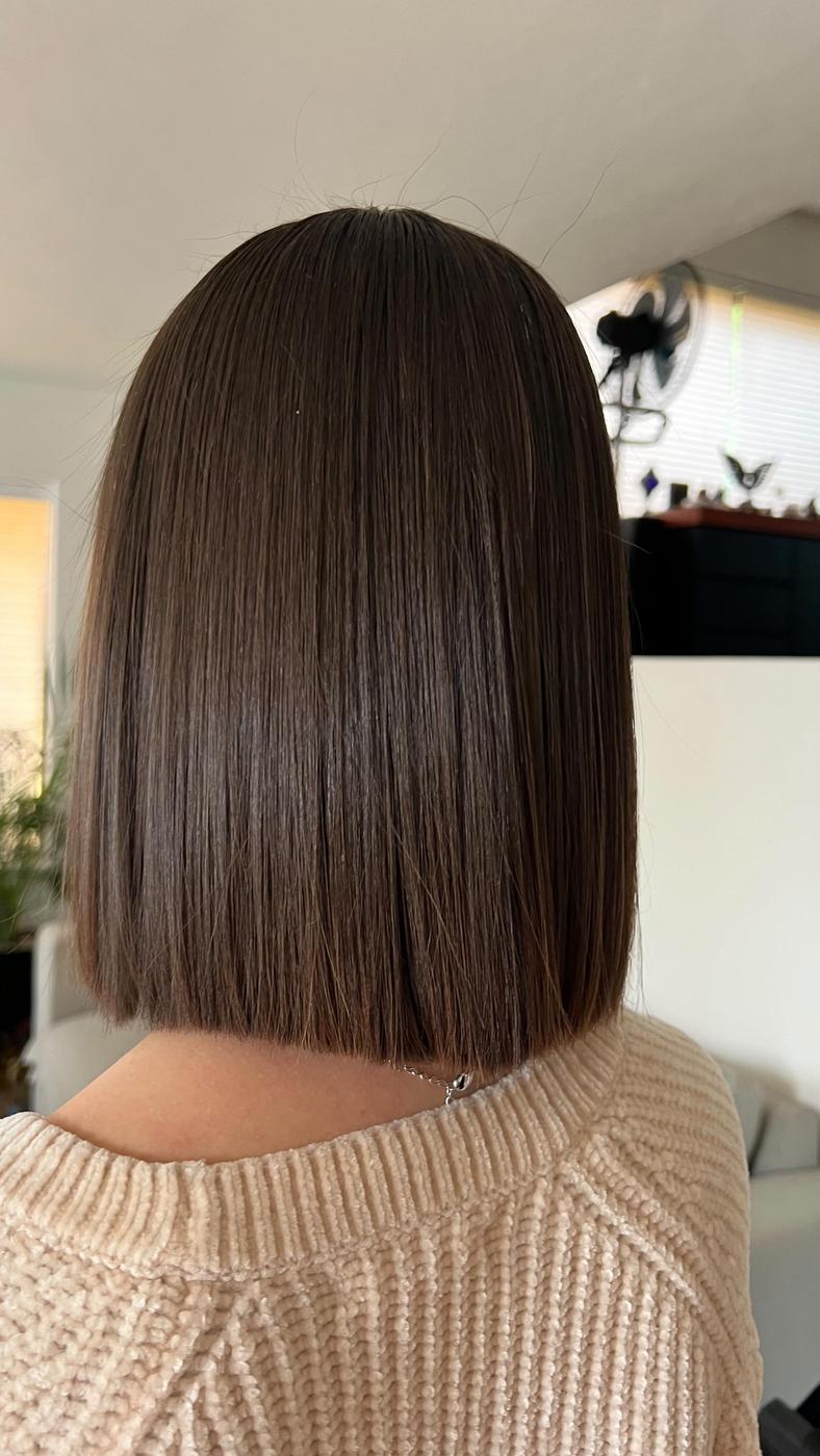 Melena castaña corta y lisa con suéter crema, vista de espaldas