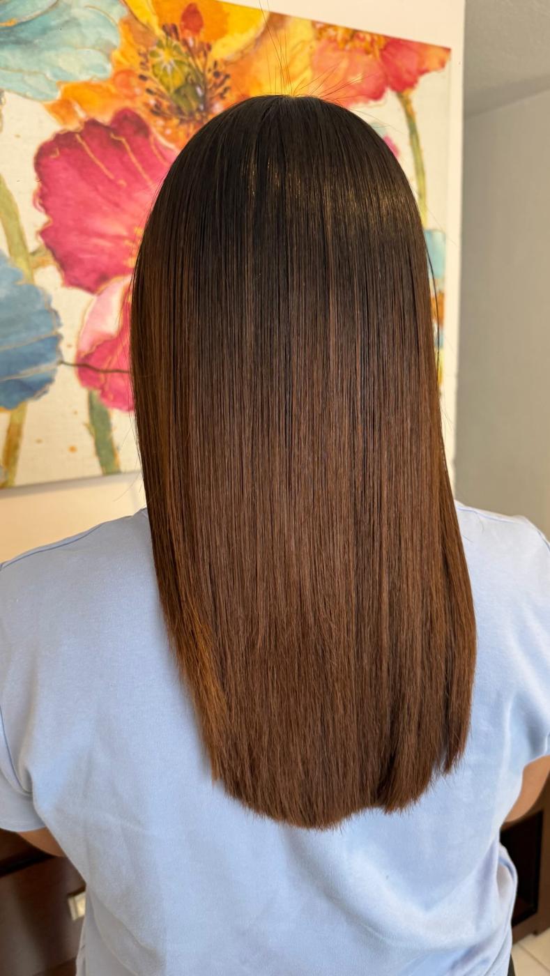 Cabello castaño medio y liso frente a un cuadro de flores, visto de espaldas