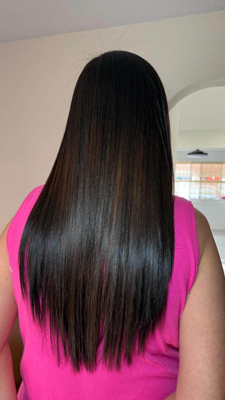 Cabello largo, negro y liso con blusa rosa, visto de espaldas