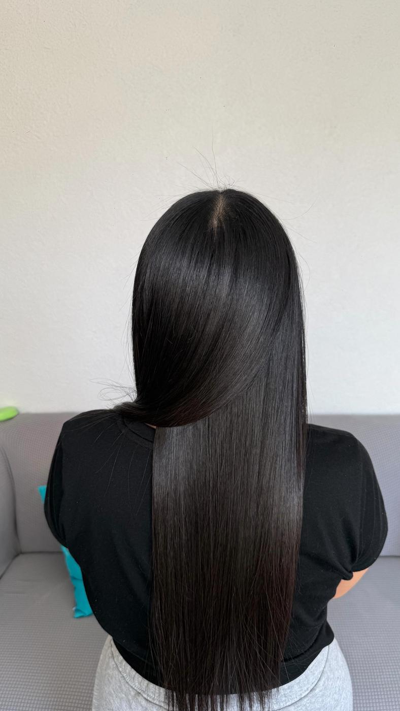 Cabello negro, liso y brillante, visto de espaldas